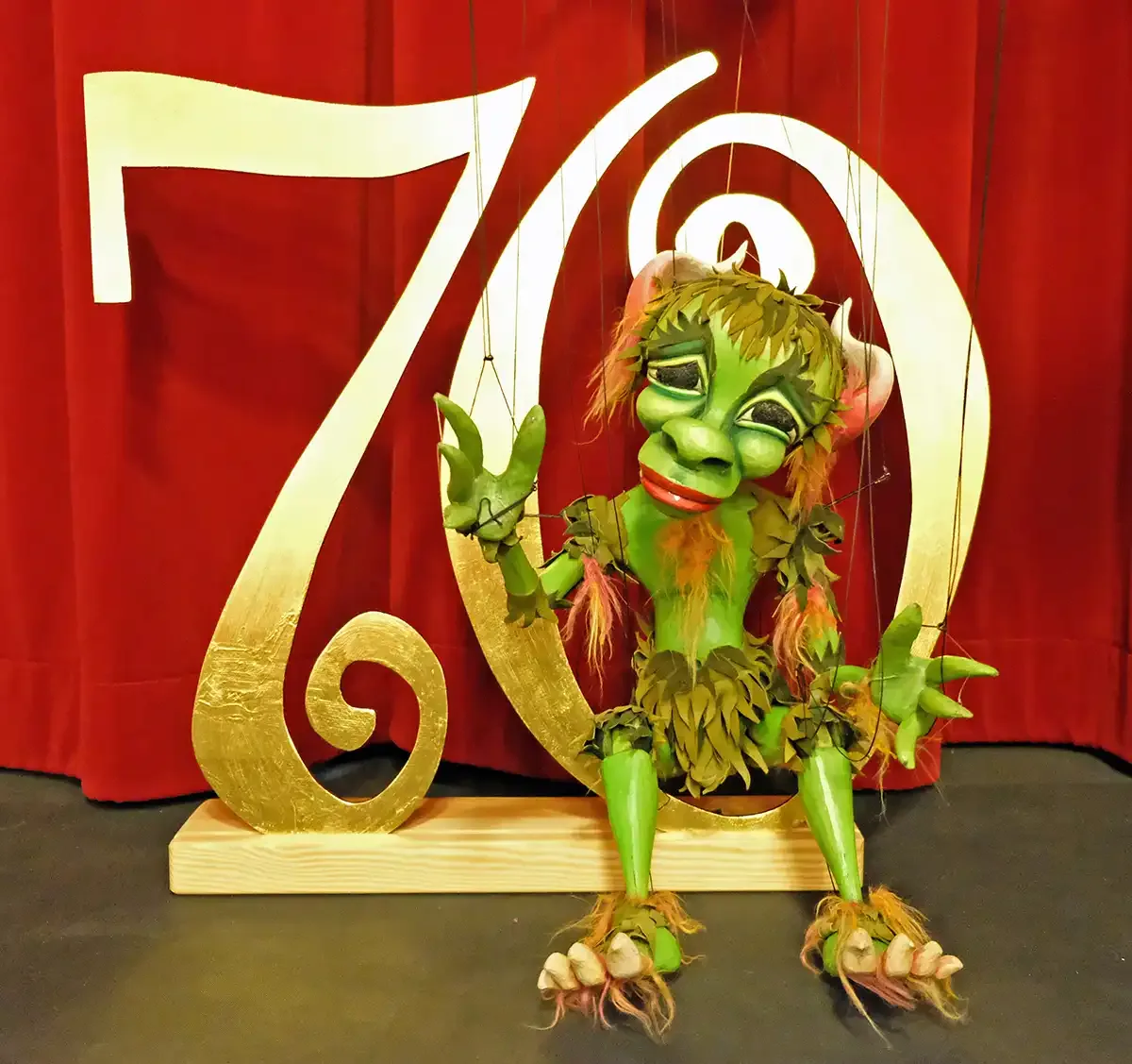 Marionette vor dem Schriftzug zum 70-jährigen Bestehen
